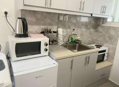 a small kitchen with a microwave and a sink at Modern 1BD Kallithea Home with Patio in Athens