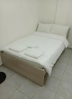 a bed with white sheets and pillows on it at Modern 1BD Kallithea Home with Patio in Athens