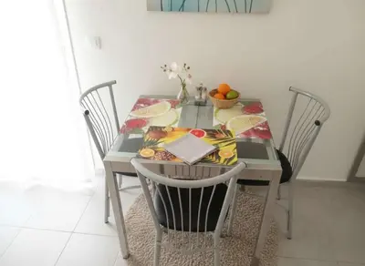 a dining room table with chairs and a bowl of fruit on it at Modern 1BD Kallithea Home with Patio in Athens