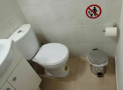 a bathroom with a toilet and a sign on the wall at Modern 1BD Kallithea Home with Patio in Athens