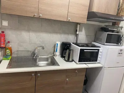 a small kitchen with a sink and a microwave at Relaxing Flat by Stavros Niarchos Park in Athens