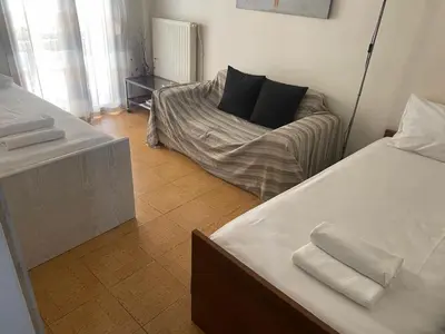 a room with two beds and a couch in it at Relaxing Flat by Stavros Niarchos Park in Athens