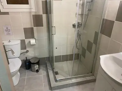 a bathroom with a shower with a toilet and a sink at Relaxing Flat by Stavros Niarchos Park in Athens