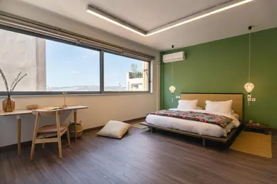 a bedroom with a bed and a desk and a window at Athens Heart Urban Zen Loft in Athens