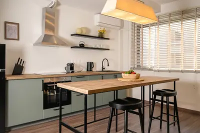 a kitchen with a wooden table and two bar stools at Athens Heart Urban Zen Loft in Athens