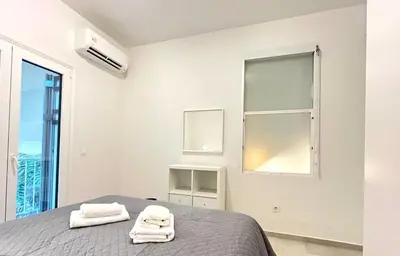 a white bedroom with two towels on a bed at New 1BR Apt modern and light in Athens