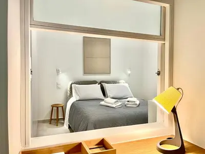 a reflection of a bedroom with a bed in a mirror at New 1BR Apt modern and light in Athens