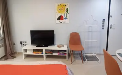 a living room with a tv and a chair at Downtown & Cozy Kolonaki in Athens