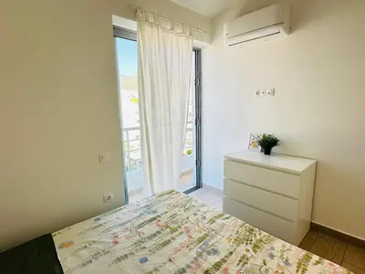 a bedroom with a bed and a dresser and a window at Top-Floor 2BR Penthouse with Stunning Sea View in Athens