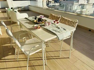 a white table and chairs with a plate of food on it at Top-Floor 2BR Penthouse with Stunning Sea View in Athens