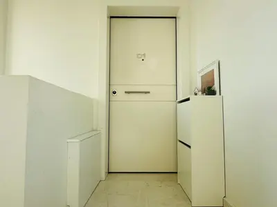 a white refrigerator and a door in a room at Top-Floor 2BR Penthouse with Stunning Sea View in Athens