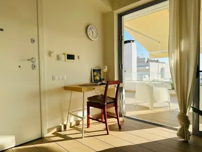 a room with a desk and a table with a clock at Top-Floor 2BR Penthouse with Stunning Sea View in Athens