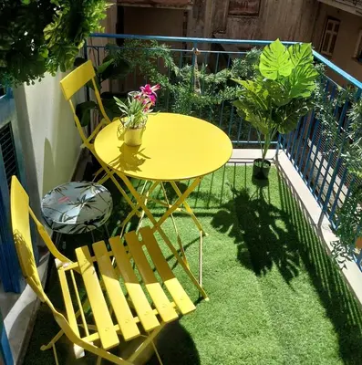 a yellow table and chairs on a balcony at Jungle Lodge Athens at metro in Athens