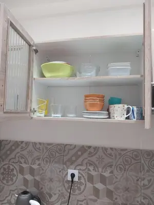 a kitchen shelf with bowls and plates on it at Jungle Lodge Athens at metro in Athens