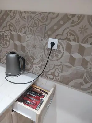 a tea kettle plugged into an electrical outlet on a wall at Jungle Lodge Athens at metro in Athens