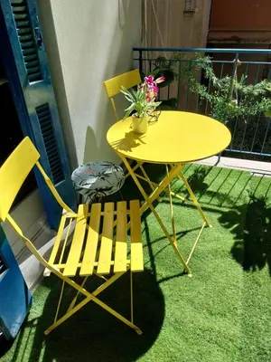 a yellow table and two chairs on a balcony at Jungle Lodge Athens at metro in Athens