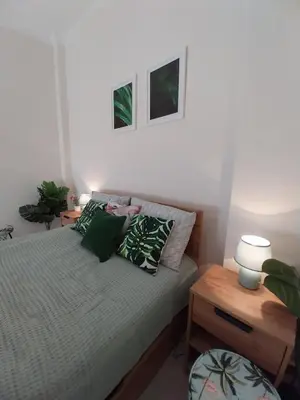 a bedroom with a bed with green pillows at Jungle Lodge Athens at metro in Athens