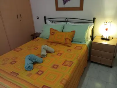 a bedroom with a bed with two slippers on it at ΕΥΧΑΡΙΣΤΗ Διαμονη in Athens