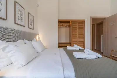 a large white bed with white pillows on it at Belle Étage 4BD 3BA Apt Kypseli Athens in Athens
