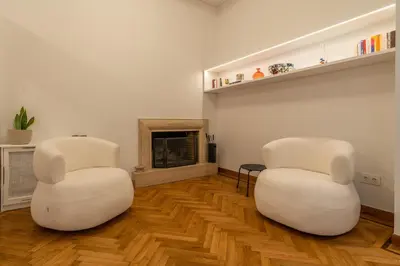 two white chairs in a living room with a fireplace at Belle Étage 4BD 3BA Apt Kypseli Athens in Athens