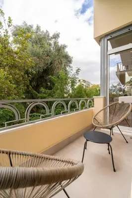a balcony with two chairs and a table at Belle Étage 4BD 3BA Apt Kypseli Athens in Athens