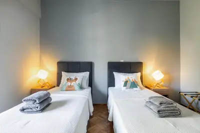 two beds in a room with towels on them at HELIOS sunny comfortable apartment in Athens