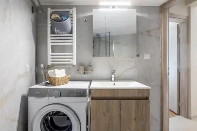 a bathroom with a washing machine and a sink at HELIOS sunny comfortable apartment in Athens