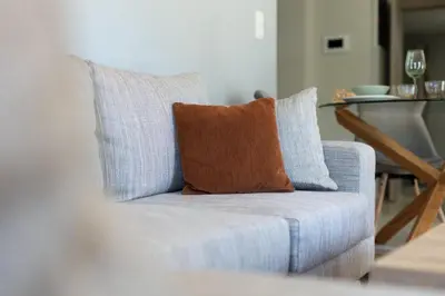 a blue chair with an orange pillow on it at HELIOS sunny comfortable apartment in Athens