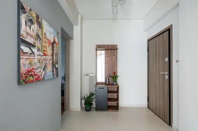 a hallway with a door and a painting on the wall at HELIOS sunny comfortable apartment in Athens
