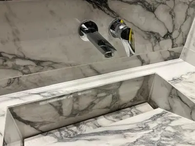 a marble sink in a bathroom with a faucet at Charming Flat with Traditional & Elegant Style in Piraeus