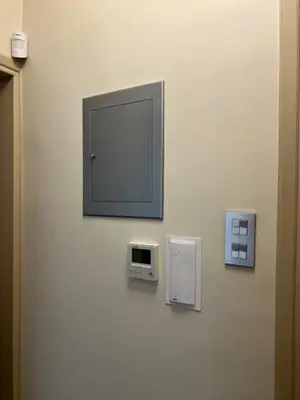 a mirror hanging on a wall with two switches at Charming Flat with Traditional & Elegant Style in Piraeus