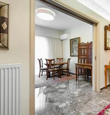 a living room with a table and chairs at Charming Flat with Traditional & Elegant Style in Piraeus