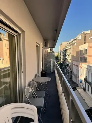 a balcony with a table and chairs on a building at Charming Flat with Traditional & Elegant Style in Piraeus