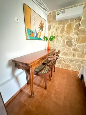 a dining room with a wooden table and chairs at Laguna in Ayía Paraskeví