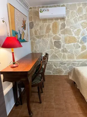 a desk with a lamp and chairs in a room at Laguna in Ayía Paraskeví