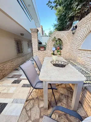 a table and chairs on a patio with a brick wall at Laguna in Ayía Paraskeví