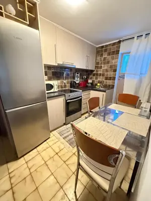 a kitchen with a table and a stainless steel refrigerator at Laguna in Ayía Paraskeví