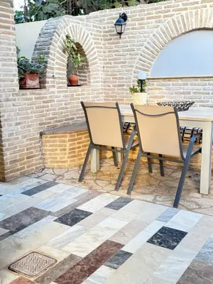two chairs and a table in front of a brick wall at Laguna in Ayía Paraskeví