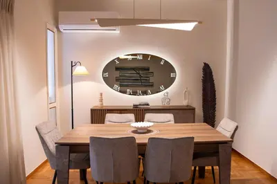 a dining room table with chairs and a large clock on the wall at Pro2Acropolis in Athens