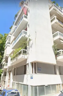 a tall white building with a car parked in front of it at Pro2Acropolis in Athens