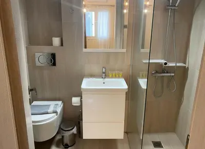a bathroom with a toilet and a sink and a shower at The Athenian Escape Elegant 2BR Apt in Galatsi in Athens