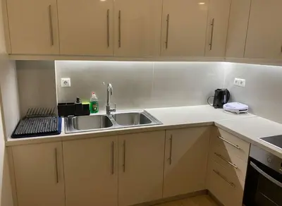 a kitchen with white cabinets and a sink at The Athenian Escape Elegant 2BR Apt in Galatsi in Athens