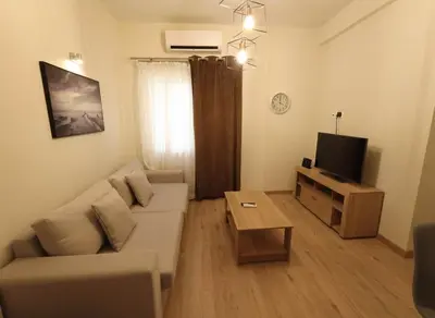 a living room with a couch and a tv at The Athenian Escape Elegant 2BR Apt in Galatsi in Athens