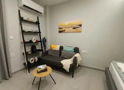 a living room with a couch and a table at Your Little Athenian Retreat Ampelokipoi Studio in Athens