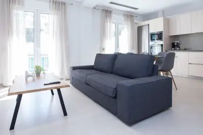 a living room with a blue couch and a table at Brand New Spacious 3 Bd Home in Trendy Kipseli in Athens
