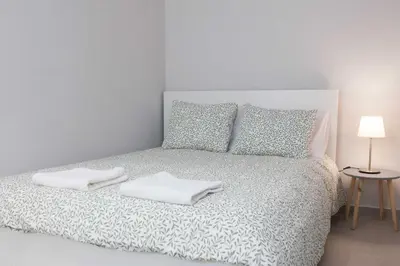 a bedroom with a bed with two towels on it at Brand New Spacious 3 Bd Home in Trendy Kipseli in Athens