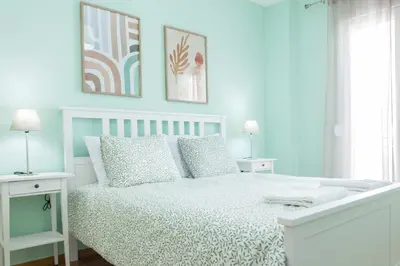 a white bedroom with a white bed and two tables at Brand New Spacious 3 Bd Home in Trendy Kipseli in Athens