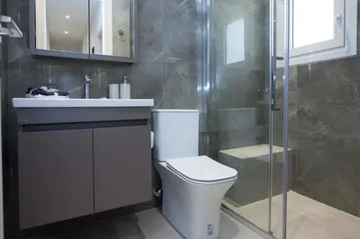 a bathroom with a toilet and a sink and a shower at Brand New Spacious 3 Bd Home in Trendy Kipseli in Athens