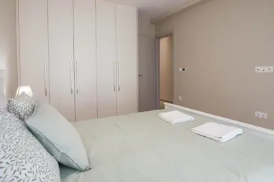a bedroom with a bed with white cabinets at Brand New Spacious 3 Bd Home in Trendy Kipseli in Athens