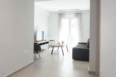 a white living room with a couch and a table at Brand New Spacious 3 Bd Home in Trendy Kipseli in Athens